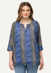 Blusa blu e beige a fantasia con maniche a tre quarti, scollatura a V e tessuto leggero e trasparente. La texture notevole crea un interesse visivo.