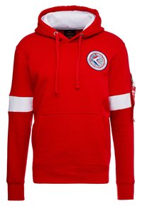 Červená mikina s kapucí s bílou vnitřní podšívkou, přední kapsou, bílým pruhem na rukávech a nášivkou s logem Apollo 18 na hrudi. Na rukávu je kapsa na zip.
