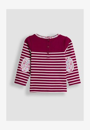 Tumšo bordo krāsas garām piedurknēm tops ar baltām svītrām, ziedu raksta elkoņu plecu ieliktņiem un trīs pogu plati aizmugurē.