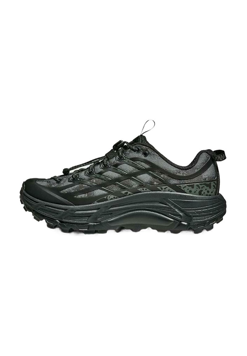 Zapatilla de trail running negra con suela robusta, parte superior de malla, sistema de cordones seguro y tiradores en el talón y la lengüeta.
