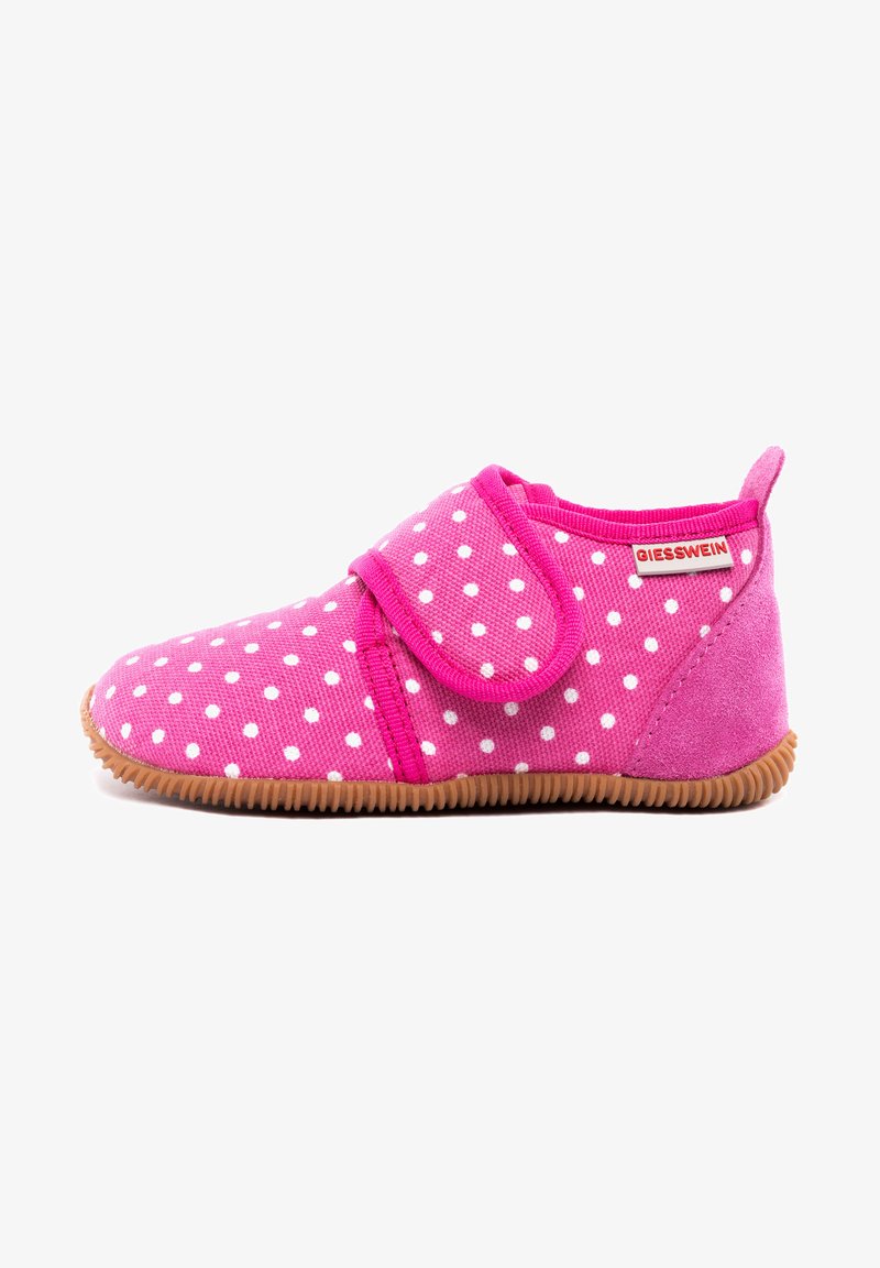 Pantoufle en tissu rose avec des pois blancs, dotée d'une bande Velcro, d'une semelle en caoutchouc marron et d'une texture douce. Étiquette de la marque visible sur le côté.