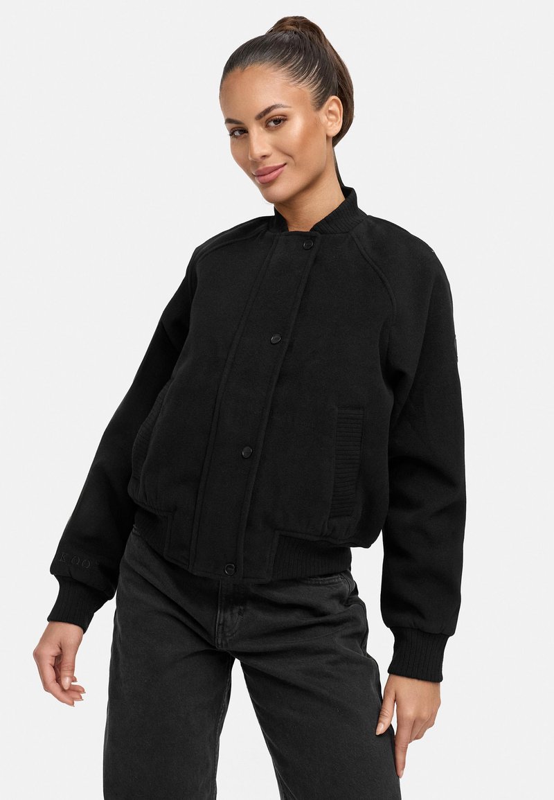Black bomber jacket made of textured fabric, featuring a ribbed collar, cuffs, and a front button closure, with side pockets and logo detail.