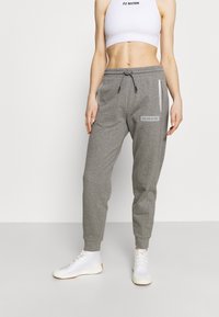 Grijze gebreide joggingbroeken met een taps toelopende pasvorm, elastische tailleband, trekkoord en zijzakken. Bevat het Calvin Klein-logo op de dij.