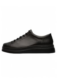 Black leather sneaker with a rounded toe, flat sole, and six eyelets for laces. Minimalistic design with subtle stitching detail.