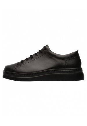 Black leather sneaker with a rounded toe, flat sole, and six eyelets for laces. Minimalistic design with subtle stitching detail.