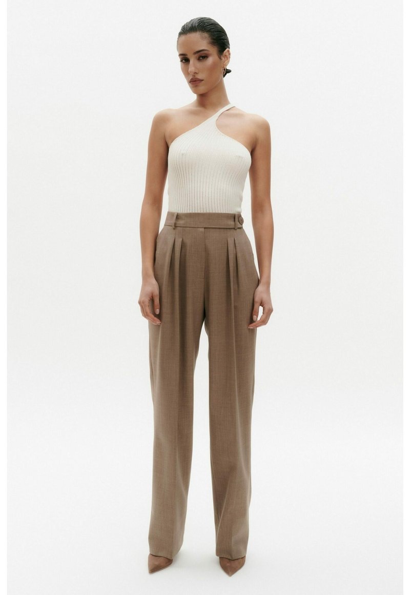 Crème ribbelgebreide top met één schouder, gecombineerd met beige geplooide broek met hoge taille, met een getailleerde pasvorm en een enkellange stijl.