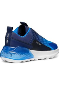 Zapatilla Geox azul con upper texturizado en forma de panal, suela blanca y cojín de talón azul translúcido, logotipo lateral visible, vista desde un ángulo trasero.