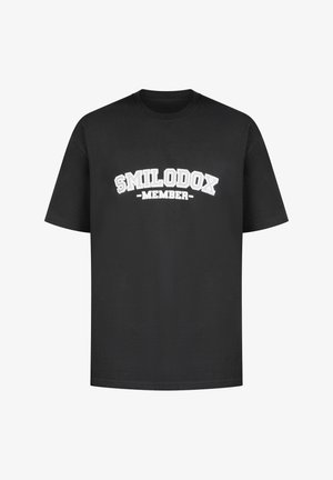 T-shirt nera in cotone a maniche corte con un design di testo curvo bianco che recita "MEMBRO SMILODOX" sul davanti.