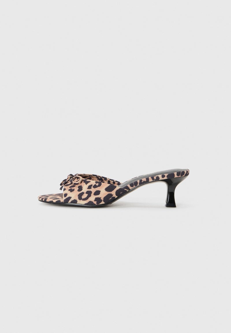 Leopard-print mules with a low, black stiletto heel. Soft fabric upper featuring a knot detail at the front and a smooth, flat sole.
