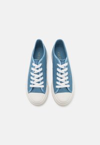 Niebieskie dżinsowe trampki z białymi sznurówkami, gumowym czubkiem i brandingiem z boku. Zaprojektowane w niskim profilu o gładkiej fakturze.