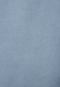 Svetlomodrá denim látka s jemnou diagonálnou textúrou tkania, ktorá ukazuje konzistentnú farbu a vzor na celej ploche.