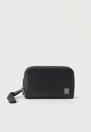 Fekete téglalap alakú bőr csuklópénztárca ezüst cipzárral és márkajelzésű címkével az elején, fehér háttér előtt bemutatva.