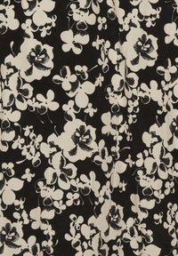 Černá látka s bílým květinovým vzorem, obsahující různé tvary a velikosti květin, husté uspořádání a strukturovaný povrch.