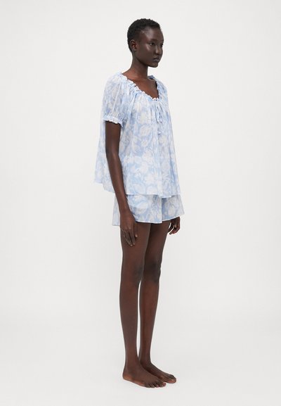 Blue floral-patterned short set featuring a lightweight, sheer top with a gathered neckline and matching shorts, both with soft textures.