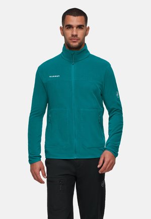 Teal fleece jack met hoge kraag, ritsluiting en twee zijzakken. Voorzien van het Mammut-logo op de borst en een rond logo op de mouw.