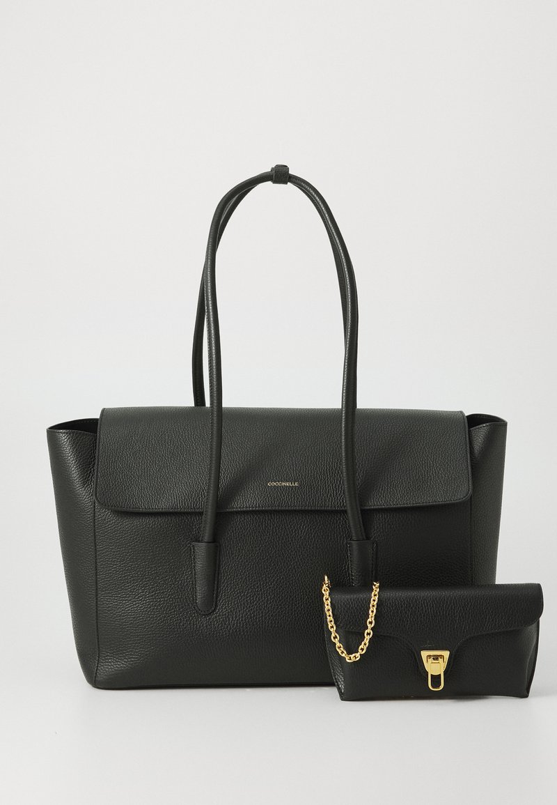 Schwarze Leder-Umhängetasche mit genarbter Textur und einem Klappenverschluss, ausgestattet mit zwei Griffen. Enthält ein kleines passendes Täschchen mit goldenen Beschlägen.