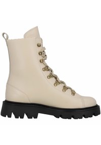 Botín de cuero beige hasta el tobillo con ojales de metal y cordones grises. Suela de goma negra gruesa con surcos profundos para tracción. Textura suave en toda la superficie.