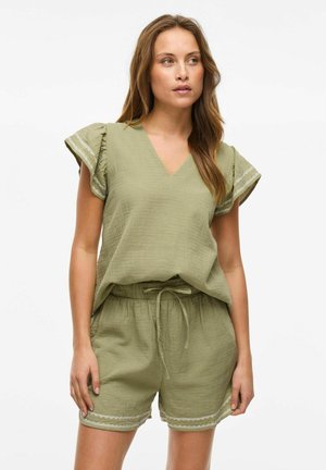 Conjunto de ropa de casa en verde oliva que presenta una blusa de escote en V con mangas acampanadas y pantalones cortos a juego con cordón y ribete decorativo.