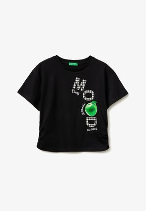 T-shirt nera a maniche corte con le lettere a scacchi "M" e "D", una grafica di una mela verde e le frasi "Vocay", "Ok What Fun" e "Est. 1965" sul davanti.