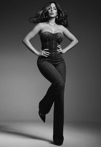 Pružný denimový korzet a rozšírené džínsy v čiernych a šedých odtieňoch, doplnené o špicaté podpätky a vrstvené šperky.