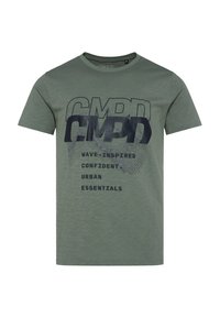 Green cotton T-shirt with short sleeves, featuring large black text “CMPD” and smaller text below in black, with a subtle textured pattern.