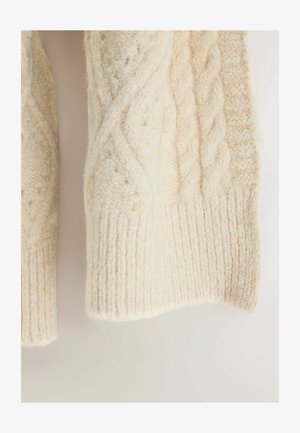 Elfenbeinfarbene Strickpullover mit dicken gerippten Bündchen. Verfügt über komplexe strukturierte Muster und eine weiche, flauschige Textur im gesamten Pulli.