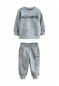 Šviesiai pilkas megztinis ir atitinkamos kelnės, abi su dažymu raižiniais. Didelis juodas "ALLSAINTS" logotipas priekyje ant megztinio.