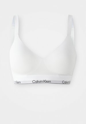 White wireless bra with a smooth texture and a curved shape. Features a black Calvin Klein logo on the elastic band. Adjustable straps.