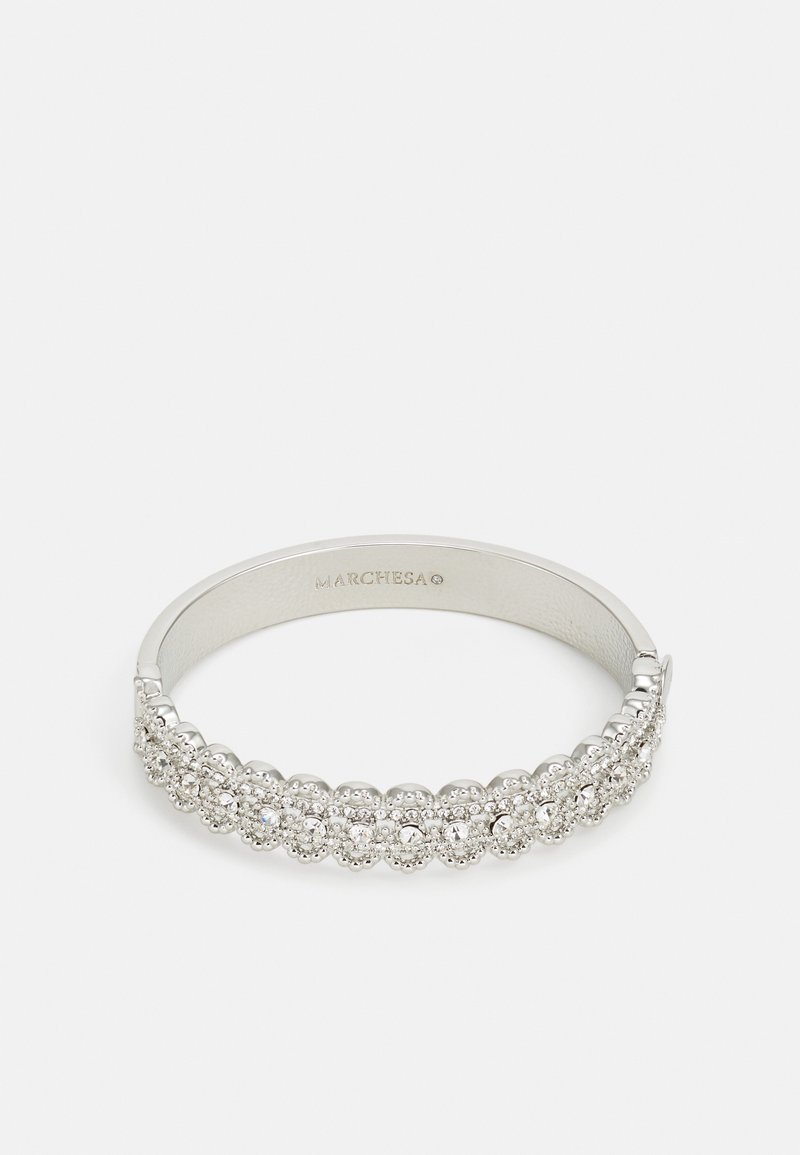 Stříbrný náramek s řadou kulatých, průhledných krystalů s texturovaným vzorem, hladkým vnitřním povrchem a zapínáním na sponu.