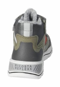 Zapatilla gris y verde oliva con un upper texturizado, rayas blancas en contraste y una suela blanca sólida. Presenta el nombre de la marca "Ricosta Reflexx."