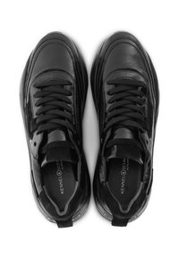 Svarta sneakers med en slät läderöverdel, texturerade detaljer och runda snören; vadderad sula, logotyp synlig på innersulan.