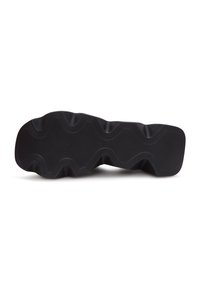 Semelle de chaussure noire avec des rainures profondes en forme d'onde et des lignes finement texturées pour une meilleure adhérence et traction.