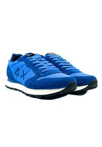 Sneaker blu in suede e tessuto, con una suola intermedia bianca, suola nera e lacci a contrasto. Il design include un logo sul lato.