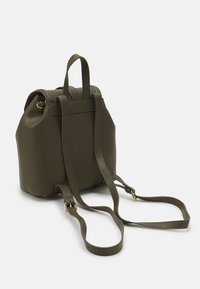 Dark green textured backpack made of leather. Features two top handles and adjustable shoulder straps. Gold-tone hardware accents.