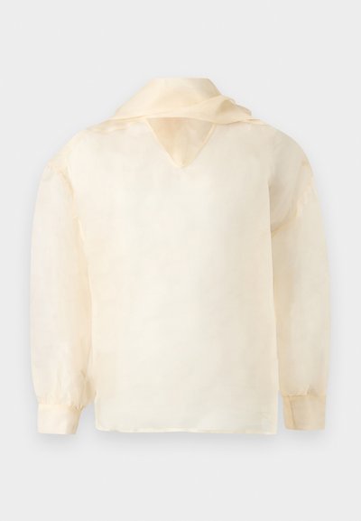 Μπεζ διάφανη μπλούζα με μακριά μανίκια, ντεκολτέ σε σχήμα V και άνετη εφαρμογή. Ιδιαίτερα μαλακή υφή με μινιμαλιστικό σχέδιο και χωρίς ορατά μοτίβα.