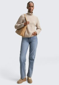 Beżowy sweter z golfem, mieszanka bawełny, luźny fason. Jasnoniebieskie dżinsy, prosty krój. Brązowa torebka na ramię i beżowe sneakersy. Minimalistyczny design.