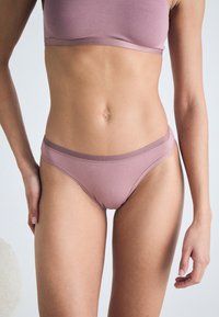 Light mauve underwear featuring a soft, stretchy fabric with a smooth texture and a low-rise design. Accented with a contrasting waistband.