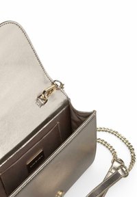 Bolso cruzado metálico de color dorado con correa de cadena y exterior texturizado. Cuenta con cierre de cremallera, bolsillo interior y placa con el logotipo.