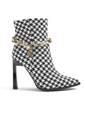 Mustan ja valkoisen houndstooth-kuvioinen nilkkapuku, jossa on terävä kärki, korkea stiletto-korko ja kultaketjuakseli, jossa on brändin logo.