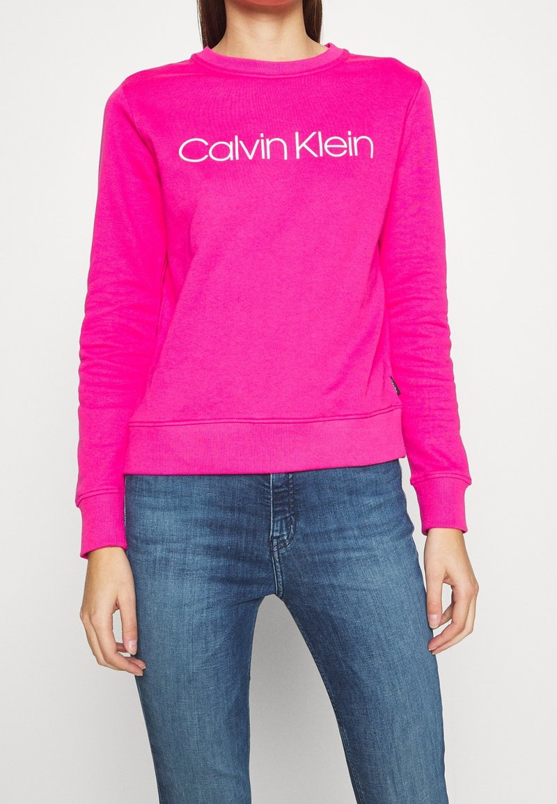 Roze sweatshirt van een katoenmengsel, met lange mouwen, geribbelde manchetten en zoom; witte "Calvin Klein"-logo-accent over de borst.