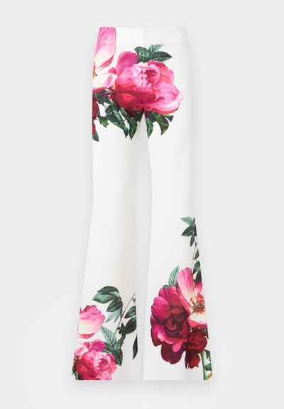 Pantalones blancos acampanados con grandes estampados florales en rosa y rojo, con hojas verdes en las caderas y parte inferior de las piernas.