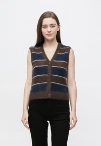 Bezrukávová pletená vesta s pruhmi v hnedej, námorníckej modrej a bielej farbe, s výstrihom do V, zapínaním na gombíky vpredu a textúrovaným fleeceovým povrchom.