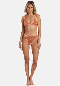 Ensemble de bikini rayé en orange et blanc, comprenant un haut bralette de soutien avec de larges bretelles et un bas taille haute. Texture lisse.