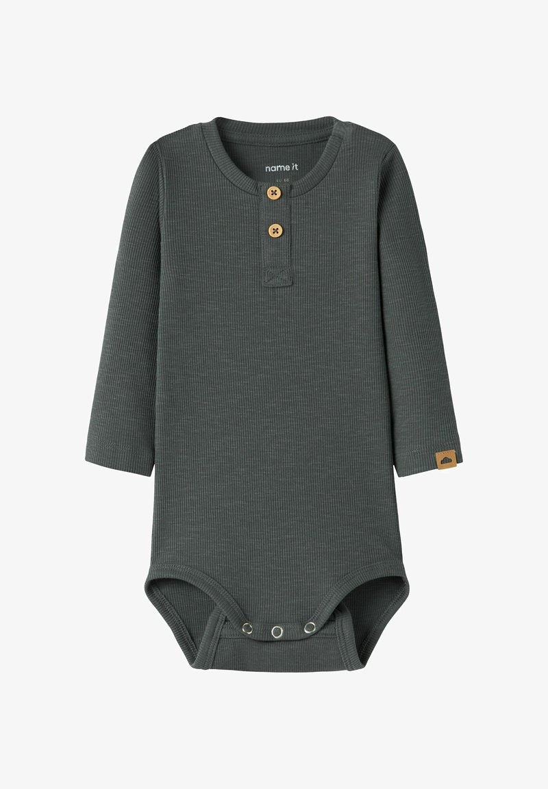 Donkergroene geribbelde body met lange mouwen, twee houten knopen bij de nek, drukknoopsluitingen aan de onderkant en een klein label op de mouw.