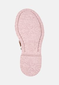 Närbild av en rosa skosula med en strukturerad yta och en Camper-logotyp präglad, som visar skons design och hantverk.