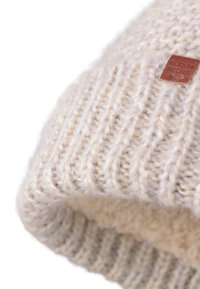 Gehaakte roomkleurige beanie gemaakt van zachte draad, met een ribbelstructuur en een leren label met de opdruk "Bickley + Mitchell".