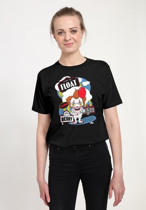 Schwarzes T-Shirt mit einer bunten Grafik eines Clowns, der einen roten Ballon hält, mit Text und cartoonartigen Elementen vor blauem Hintergrund.