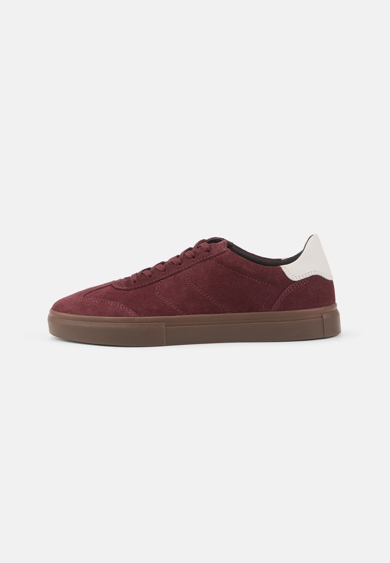 Burgundy suede sneakers with tonal stitching, a contrasting white heel cap, and a brown rubber sole. Simple, low-profile design.