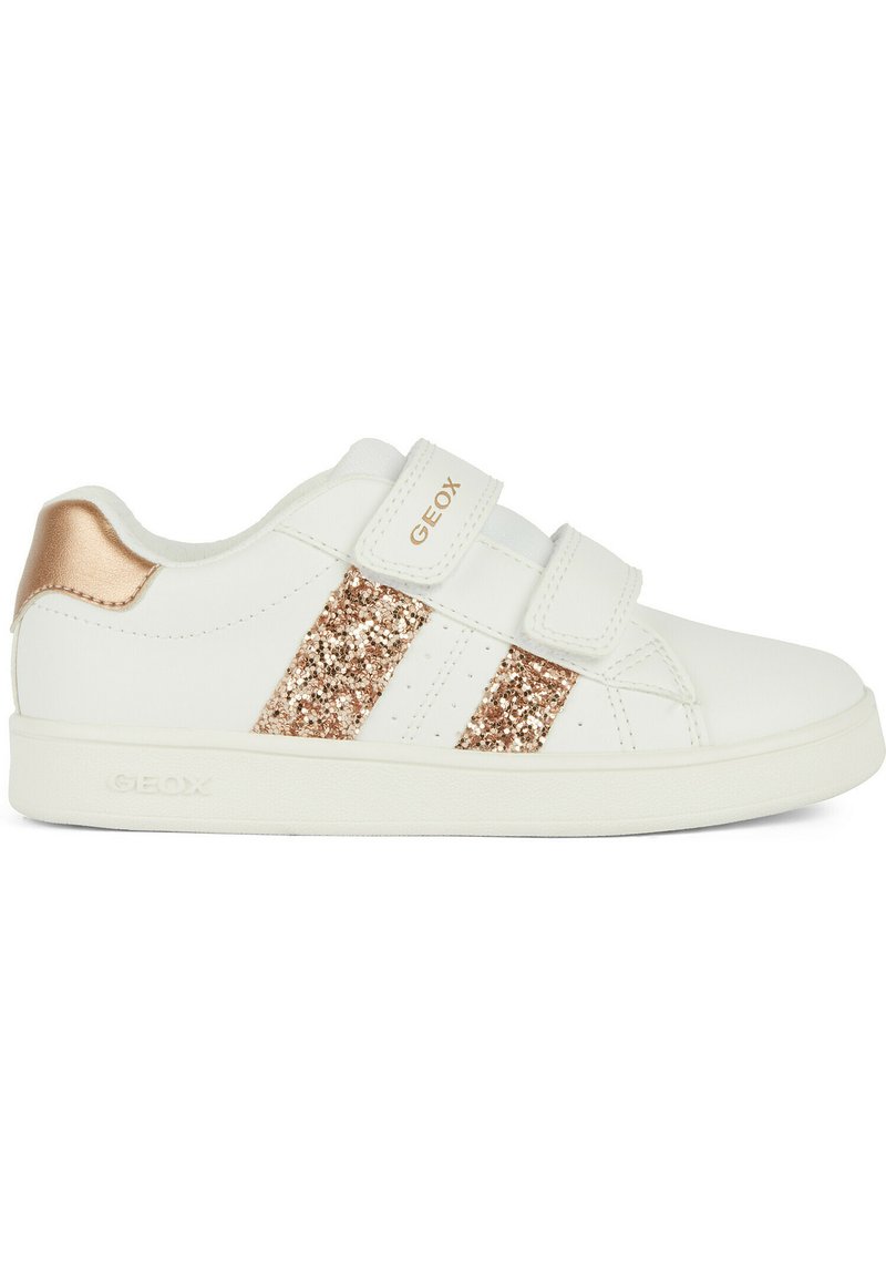 Baskets blanches avec des rayures en paillettes rose doré et un accent métallique au talon. Elles sont dotées de deux bandes Velcro et d'une semelle en caoutchouc texturée.