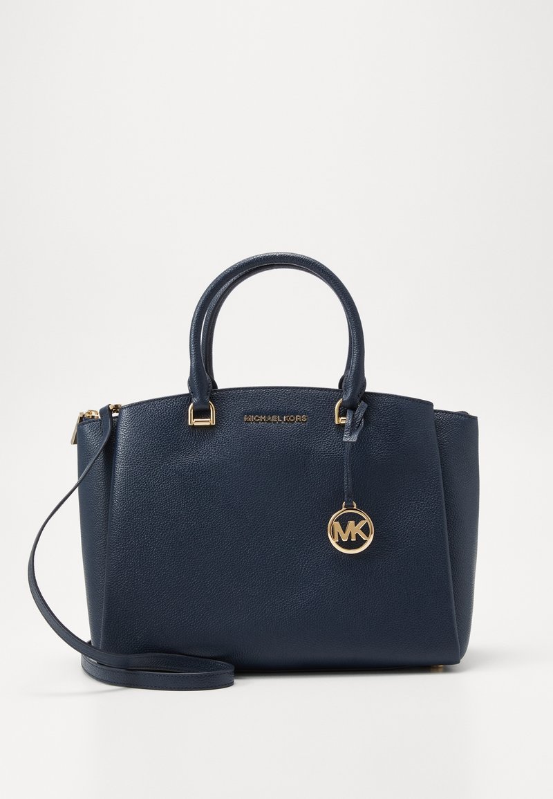 Sac à main en cuir texturé bleu marine avec double poignée, bandoulière amovible, breloque dorée "MK" et logo Michael Kors sur le devant.